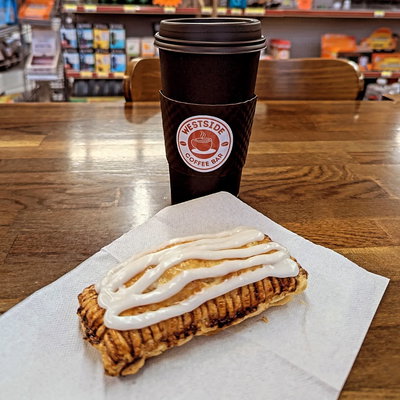 A pastry and a Westside Coffee Bar to-go cup on the counter