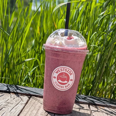A berry smoothie in a Westside Coffee Bar cup, out by the grass